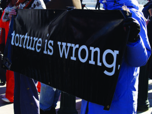 Cartel de una concentración frente a Guantanamo que reza "torture is wrong